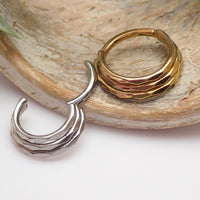 Three stacked beveled 16g Body Clickers body jewelry clicker with beveled edges and silver finish.