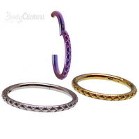Titanium clicker body jewelry with crisscross etchings, available in 8mm, 10mm, and 12mm sizes, by Body Clickers.
