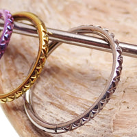 Titanium crisscross-etched clicker body jewelry in 16g with engraved design, featuring 8-12mm size options.