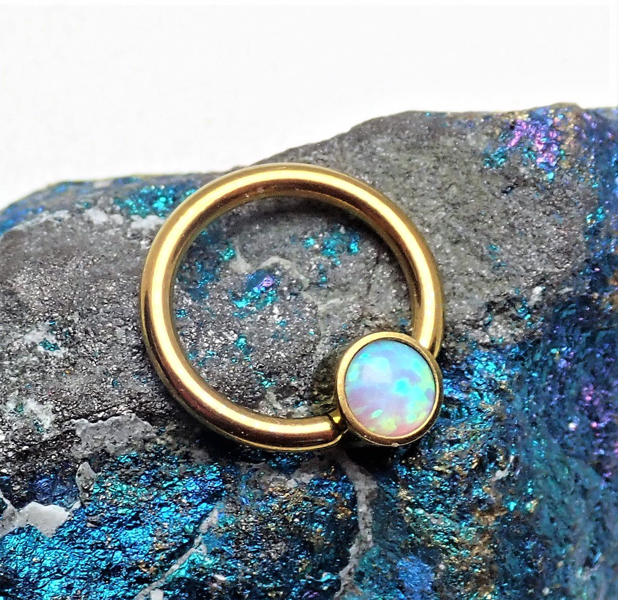 Gold and opal titanium CBR body jewelry by Body Clickers, featuring 8mm size with vibrant opal accents.