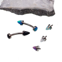 Curved body jewelry with opal spike and cabochon top in 14g, featuring a sleek, modern design by Body Clickers.