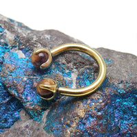 16g Tiger's Eye horseshoe body jewelry by Body Clickers, featuring polished tiger's eye stones and a horseshoe shape.