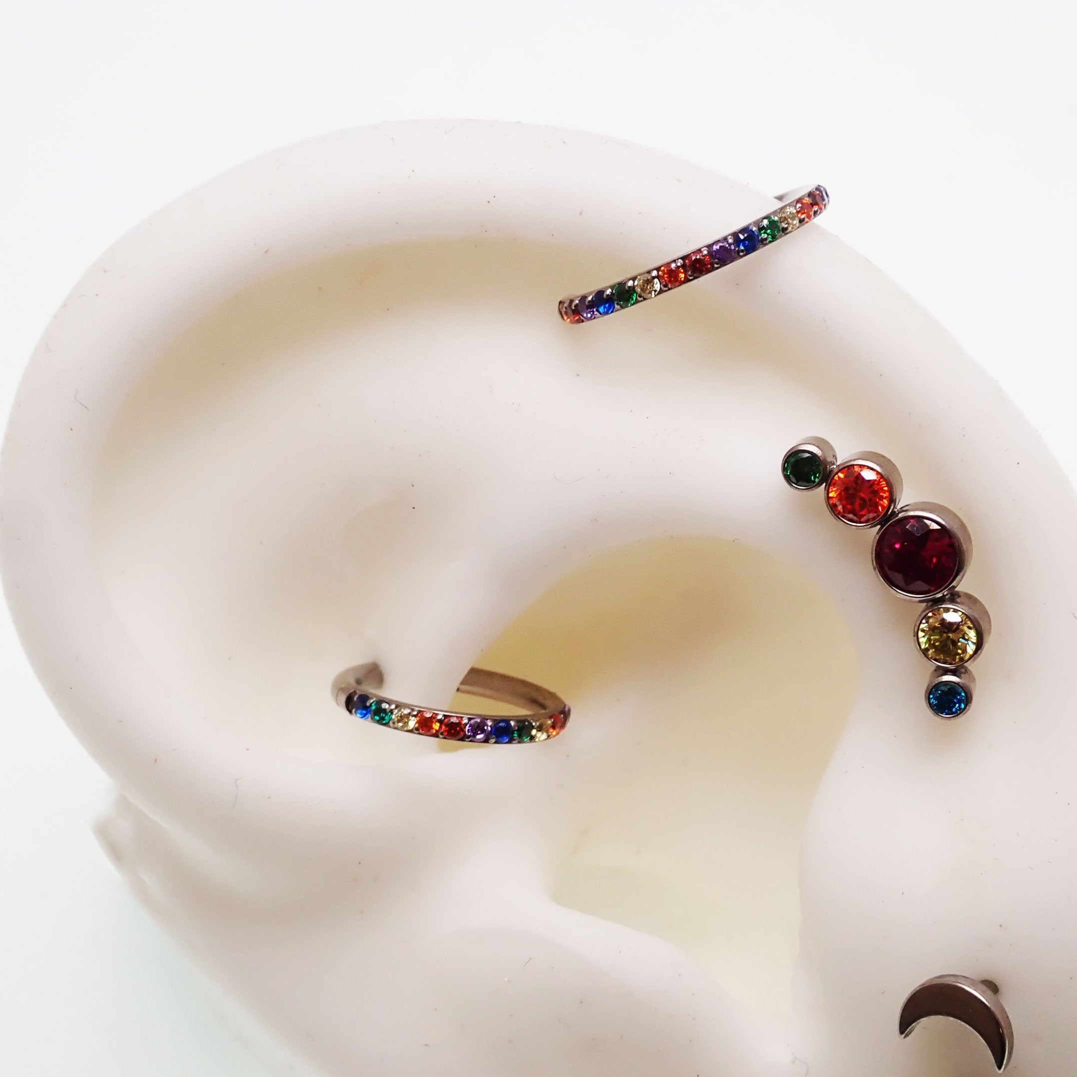 Titanium multi-stone CZ stone clicker body jewelry in 16g with 8mm diameter, featuring colorful stones and a sleek design.