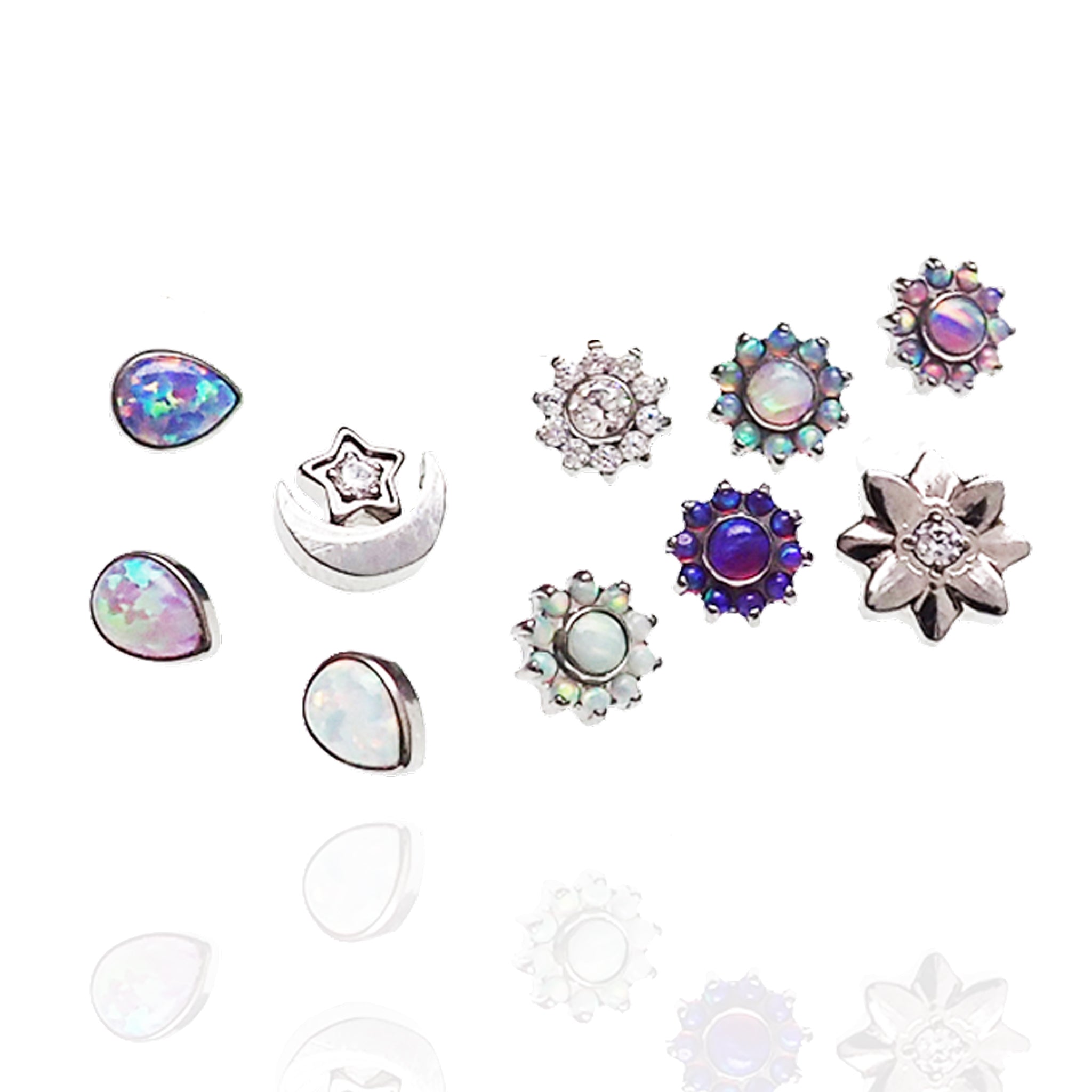 CZ Daisy, Opal Tear, and Moon dermal titanium tops for 14g body jewelry by Body Clickers, shown on a display.