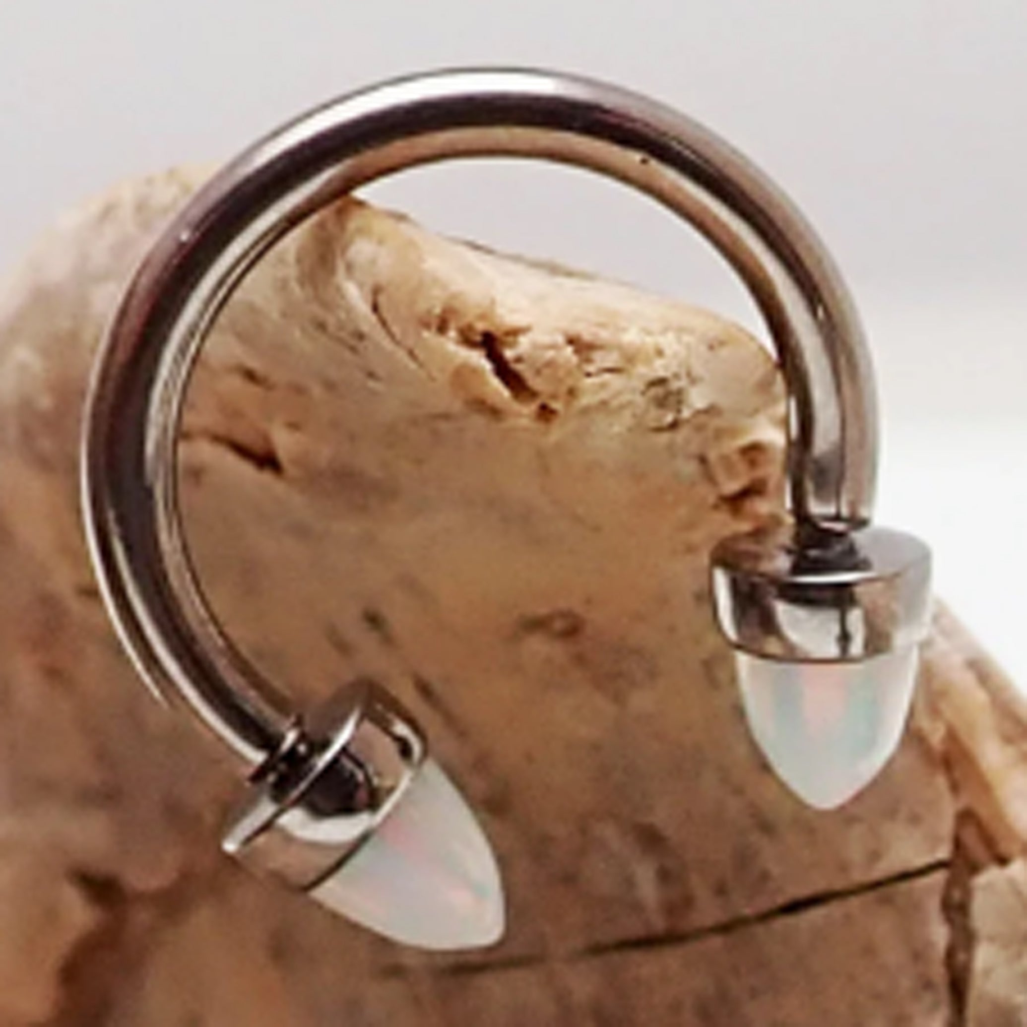 Black horseshoe piercing with 3mm spiked opal cone ends, 16g body jewelry by Body Clickers, featuring a curved horseshoe shape.
