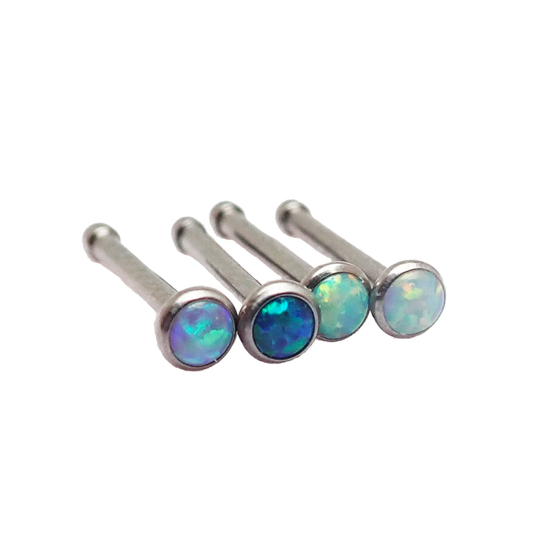 Four titanium nose bone studs from Body Clickers Body Jewelry, shown in various angles, ideal for body piercing jewelry.