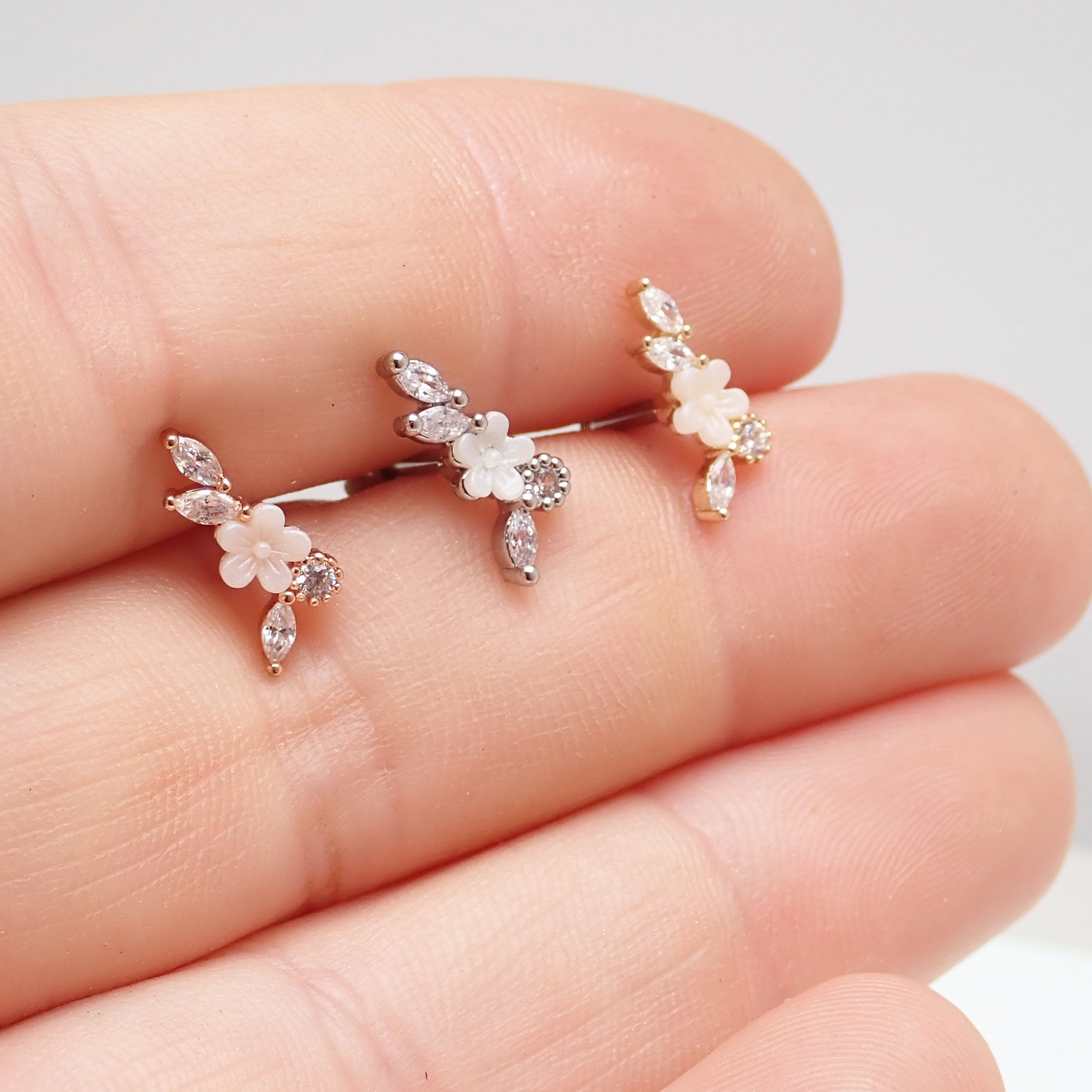 Brass helix flower body piercing with CZ stones, 16g, showing detailed floral design and sparkling gemstone accents.