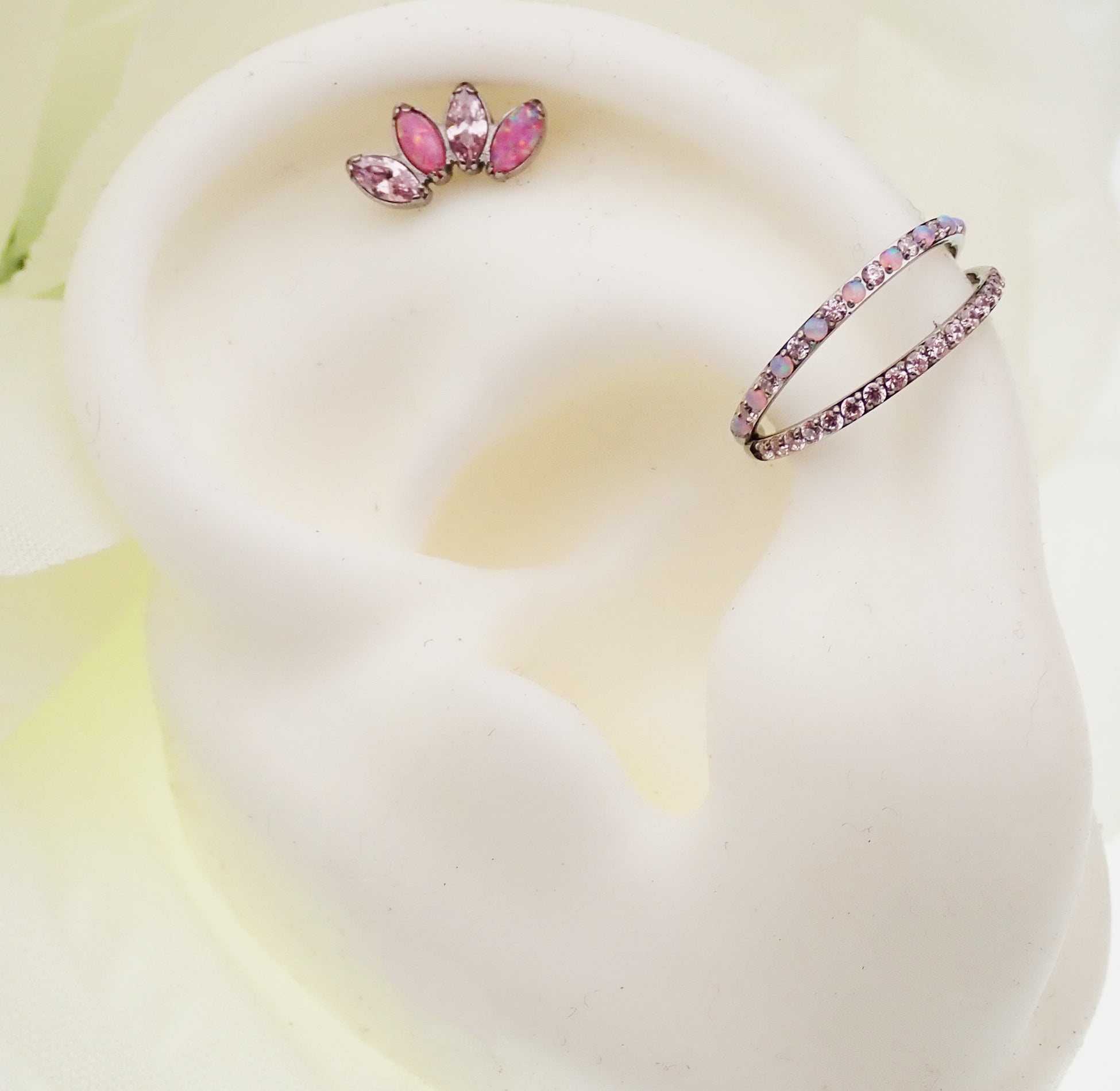Double layer 16g split opal and CZ titanium clicker body jewelry, showcasing its elegant design and secure clicker clasp.