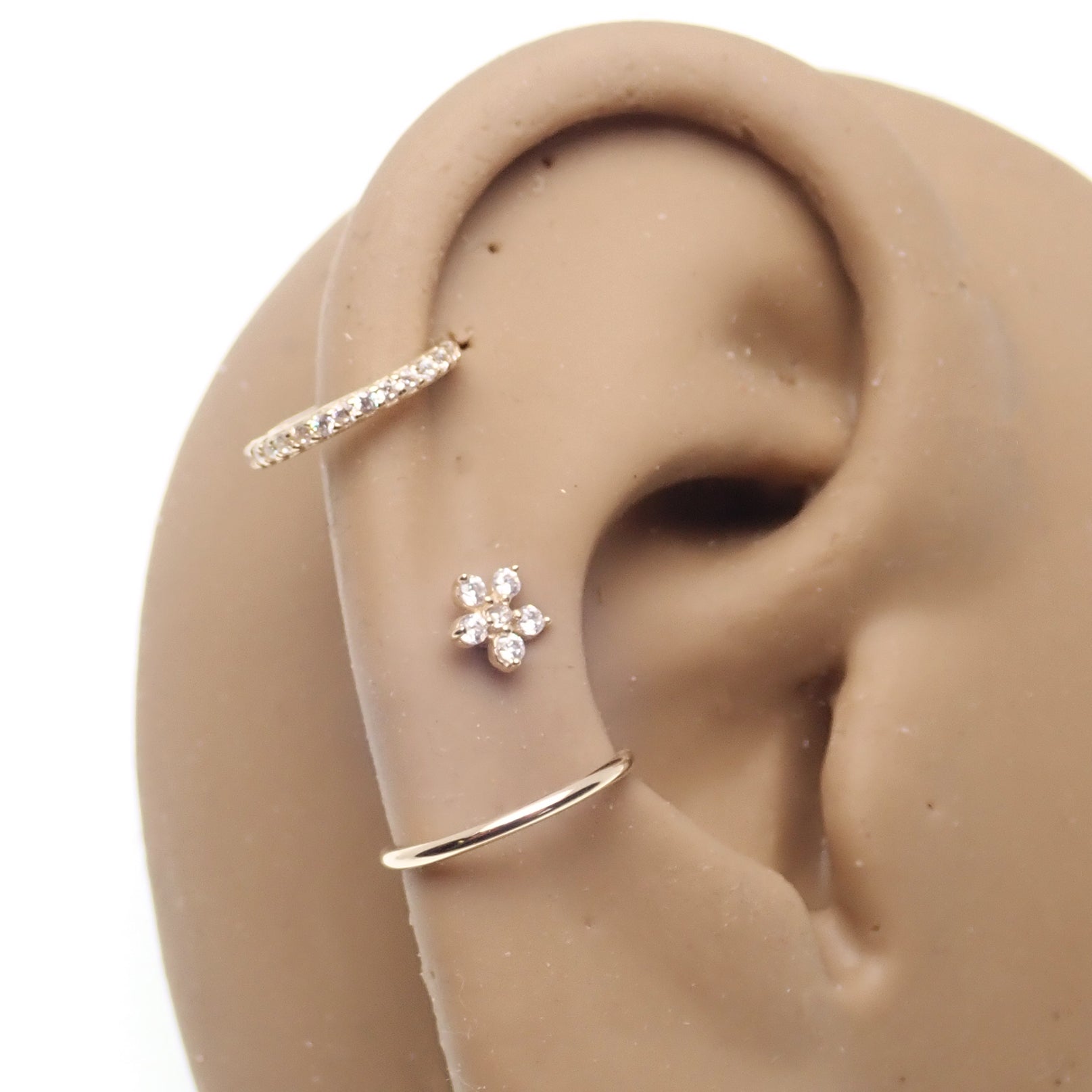 14k gold CZ Flower barbell body jewelry with sparkling CZ stones, 16g from Body Clickers featuring a delicate floral design.