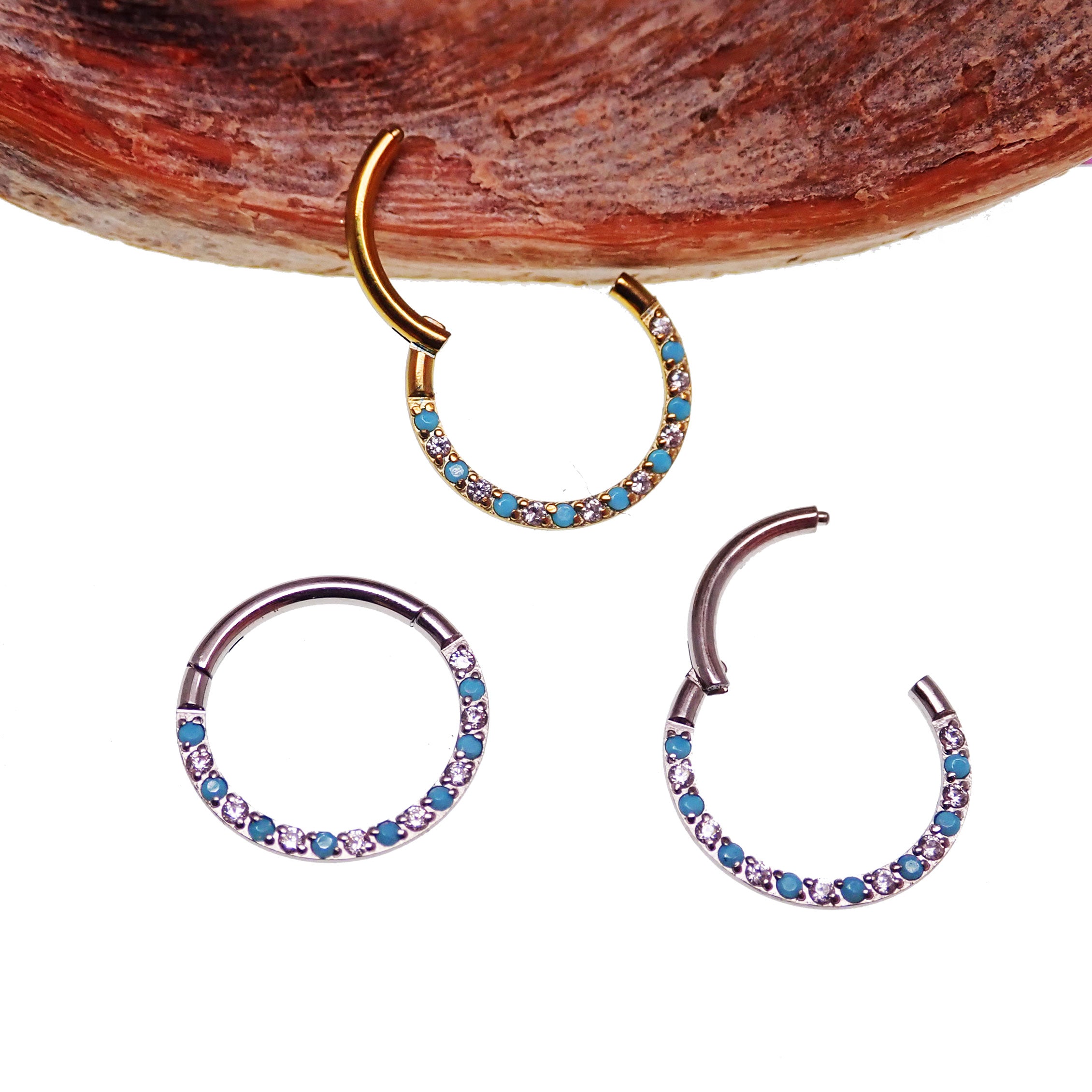 Front-facing 18g titanium turquoise and CZ alternating clicker body jewelry with sleek design and vibrant colors.