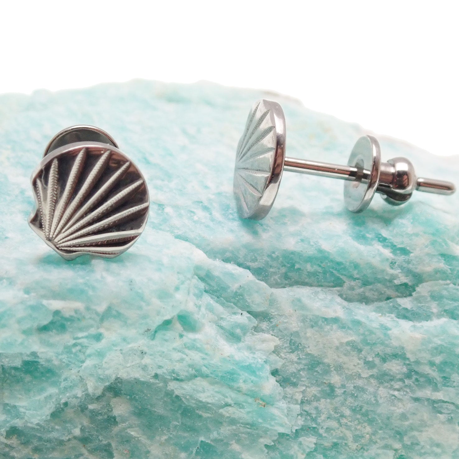 Titanium shell design earrings in 20g body jewelry by Body Clickers, featuring a sleek implant-style shell shape.