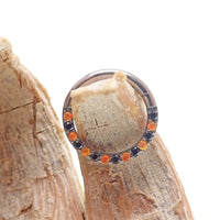 Orange and black CZ titanium clicker body jewelry, 16g, with sleek design and sparkling stones for pierced piercings.