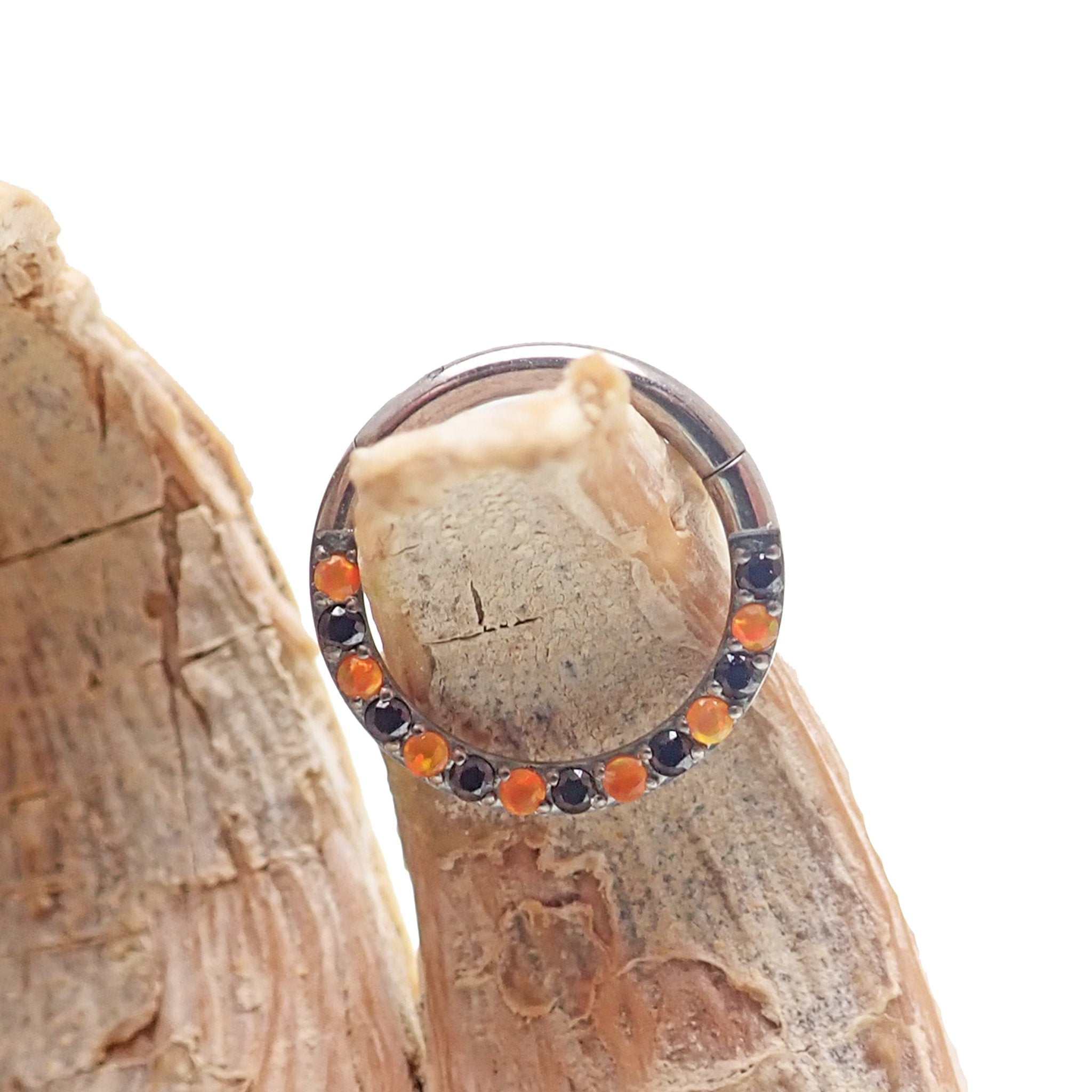 Orange and black CZ titanium clicker body jewelry, 16g, with sleek design and sparkling stones for pierced piercings.
