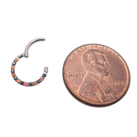 Orange and black CZ titanium clicker body jewelry in 16g with a sleek design, featuring sparkling CZ stones for a stylish look.