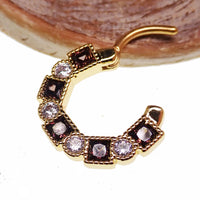 Steel clicker body jewelry with amber and clear CZ stones, 16g, featuring a sleek design and sparkling accents.