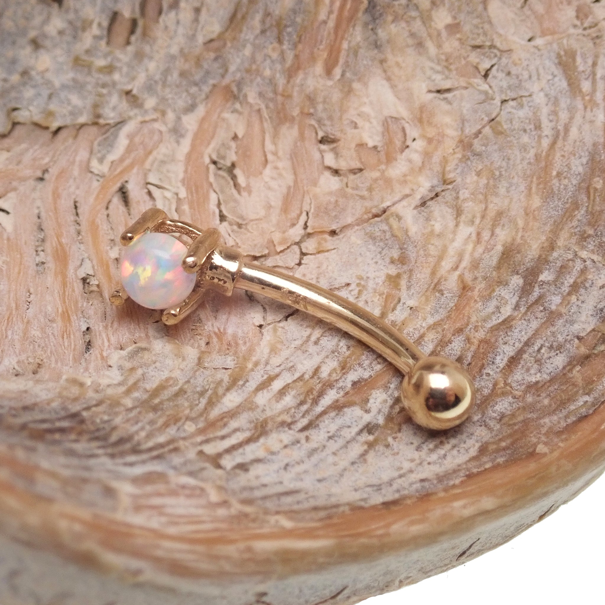 White opal and gold ball body jewelry by Body Clickers, 14k gold curve, 16 gauge piercing, featuring a polished white opal and gold accents.