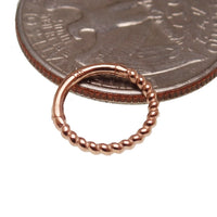Gold and rose gold 14k gold twisted 8mm clicker body jewelry in 16g by Body Clickers, showing the jewelry's design and shine.