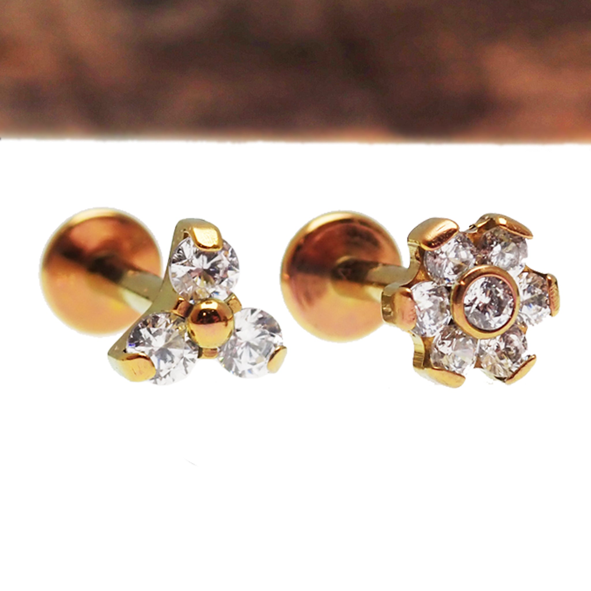 Two-piece set of clear cubic zirconia Trinity and flower titanium flatback earrings in 14g, 16g, and 18g body jewelry.