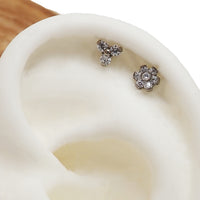Pair of clear CZ Trinity and flower titanium flatback earrings in 14g, 16g, and 18g sizes, featuring sparkling jewelry designs.