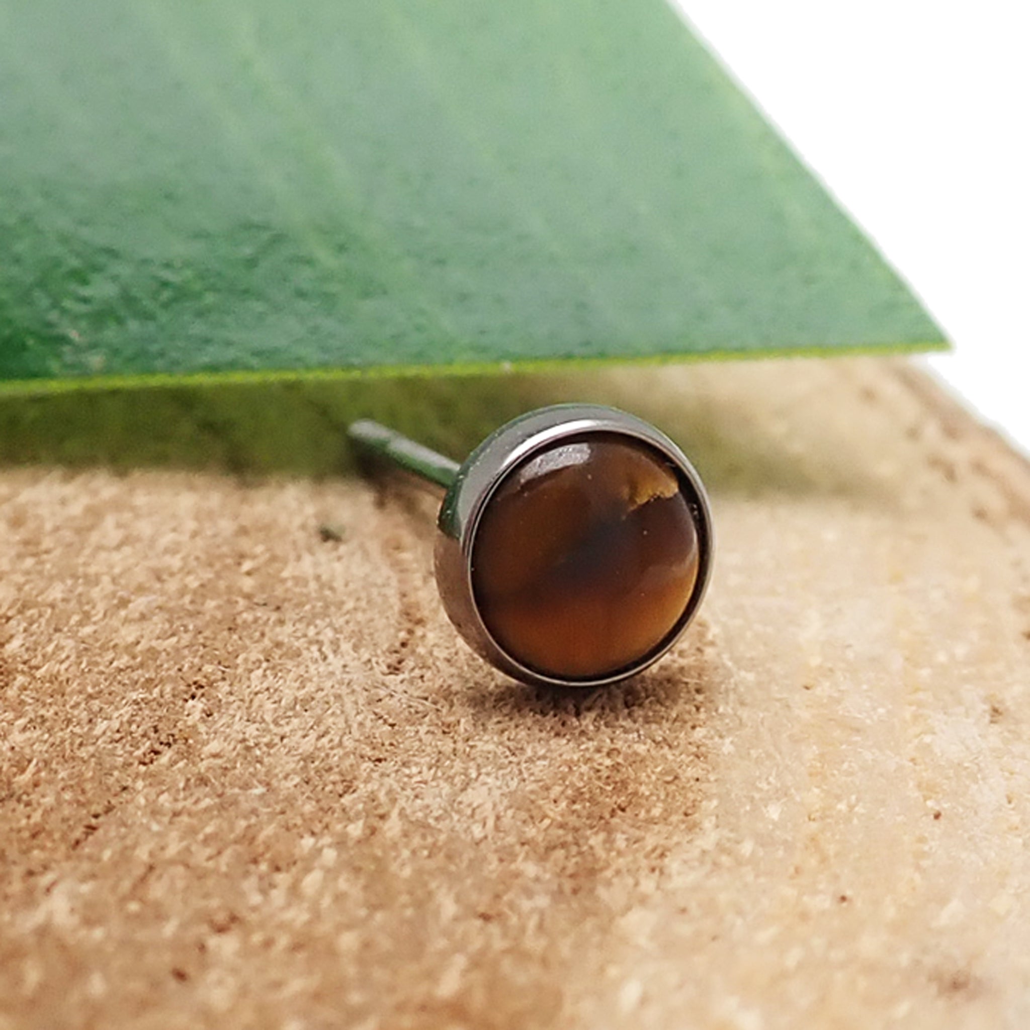 Pair of Tiger's Eye titanium earrings by Body Clickers, featuring polished gemstone accents and sleek earring design.