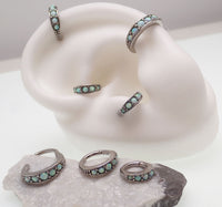 Surgical steel hinged clicker with opal beadwork for body piercing jewelry, featuring a 6mm diameter and secure hinge closure.
