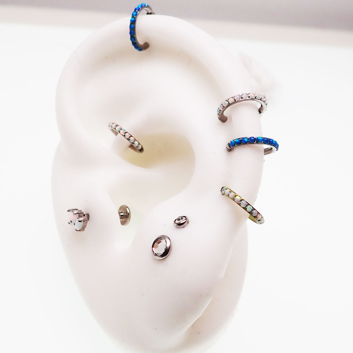 Blue opal inlaid 6mm hinged clicker earrings by Body Clickers, 16g, with a sleek, polished design for body piercing jewelry.