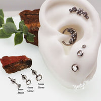 HALOBES titanium earrings with zircon crystal accents, showcasing a sleek design and sparkling gemstones.
