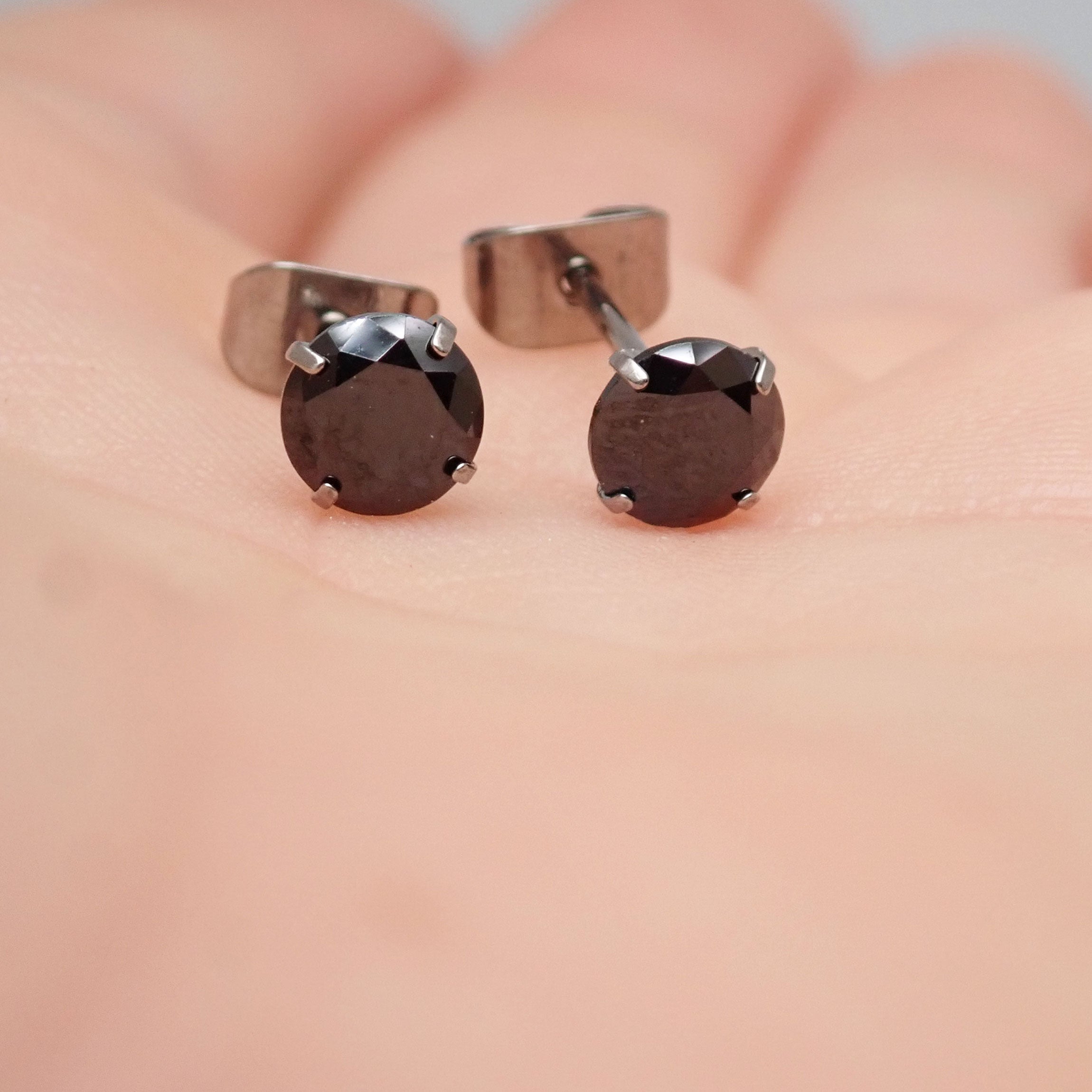 Black CZ implant titanium earrings in 20g, featuring a sleek design and secure post, by Halobes.
